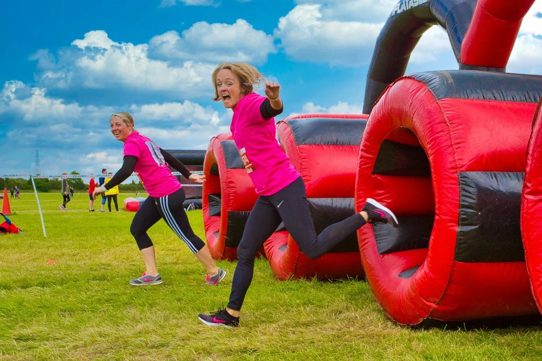 Participants run through huge inflatable red and black tubes