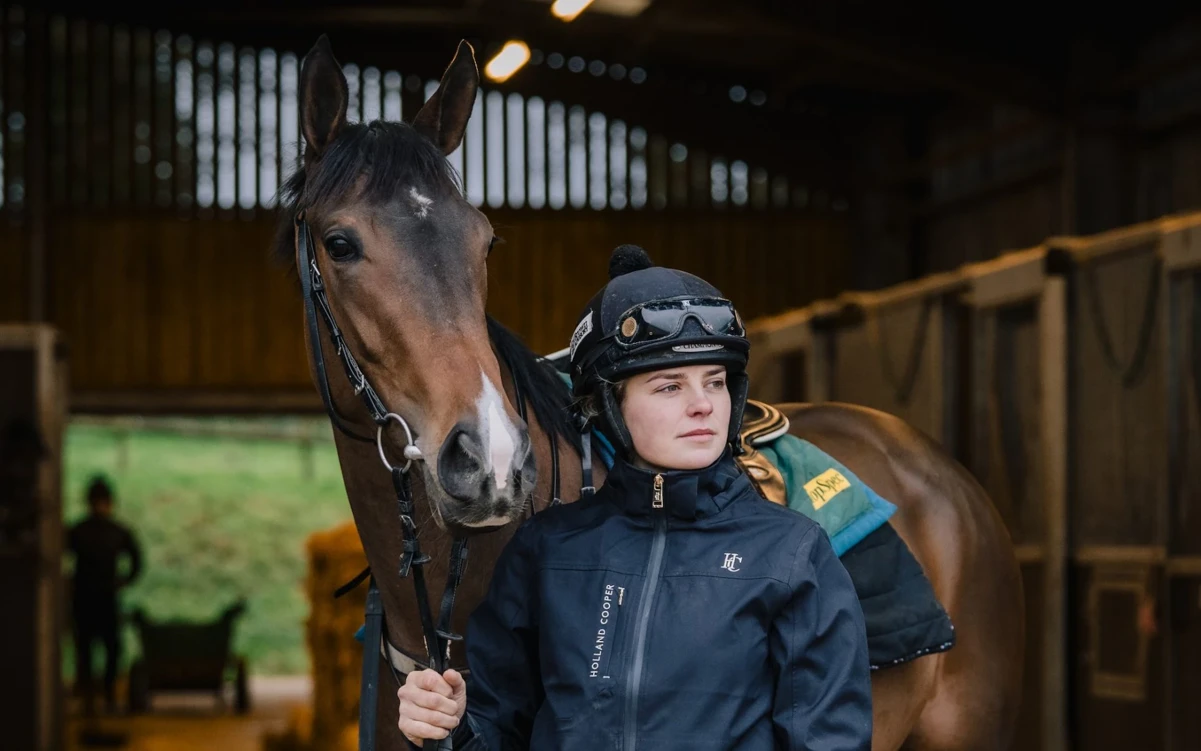 Lily Pinchin stood in riding gear next to a horse
