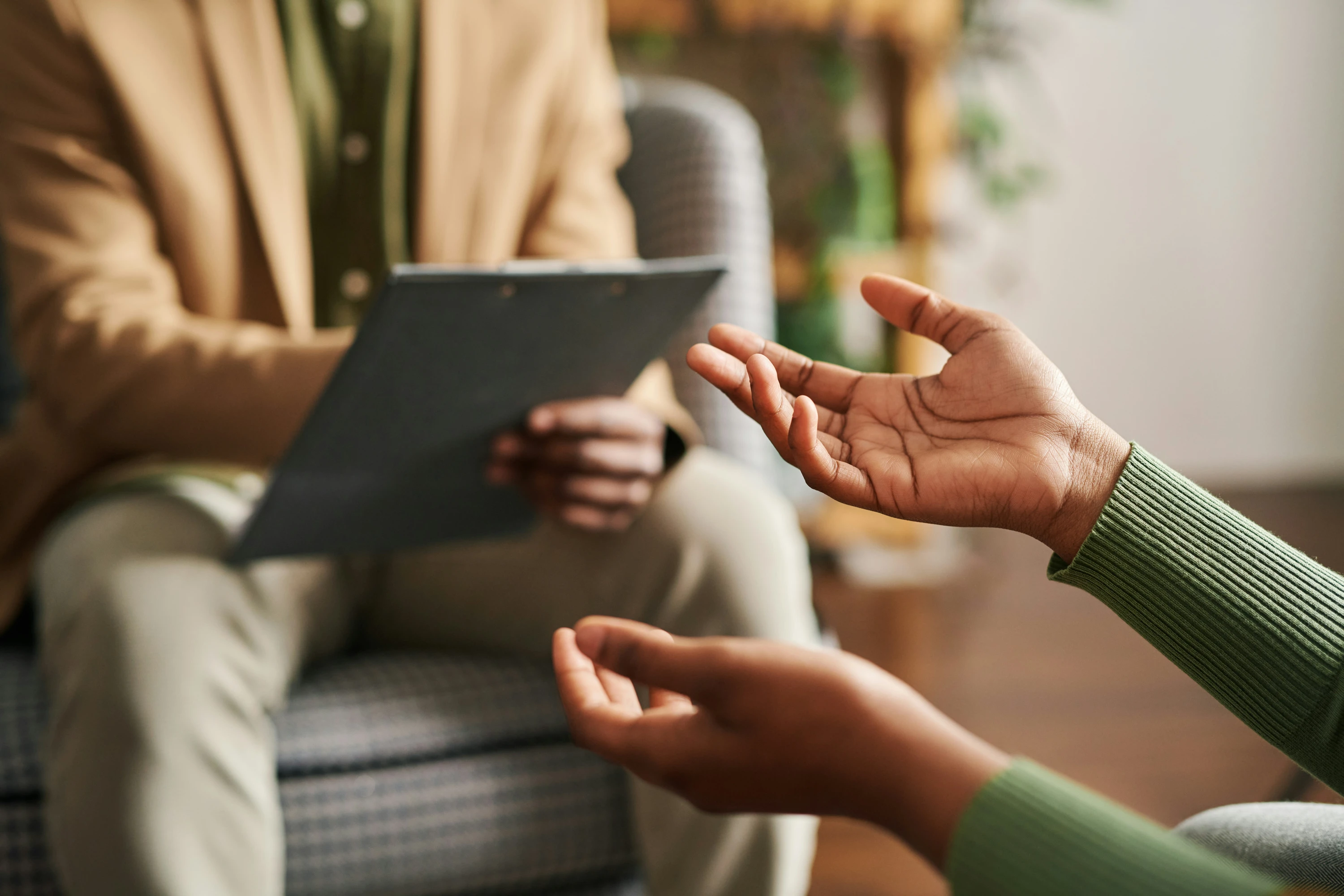 Hands of young black woman describing something to someone sitting in front of her